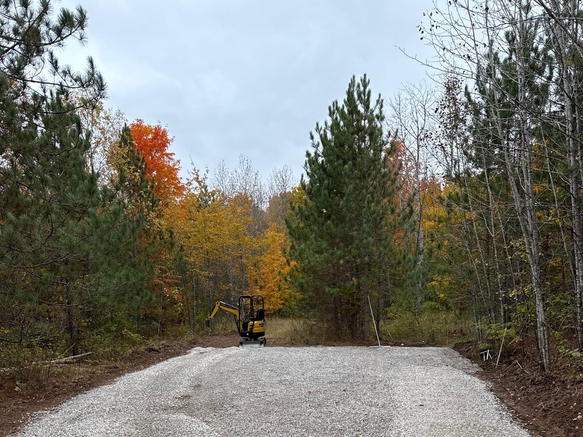 Finished gravel driveway surrounded by autumn woods